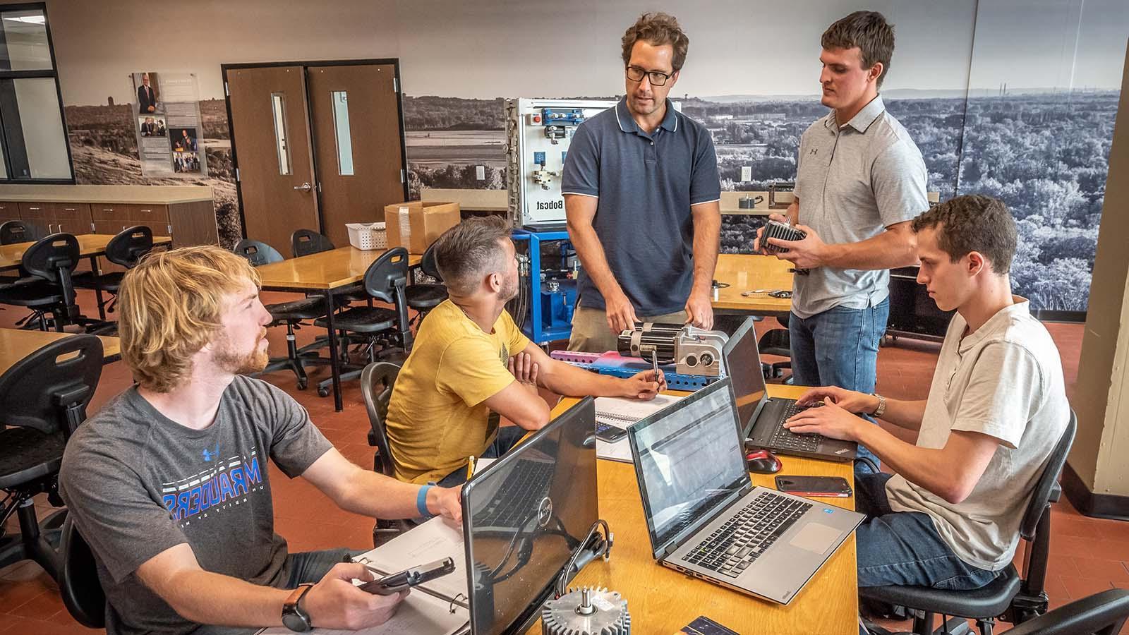 Engineering students meeting with professor in the new design center 